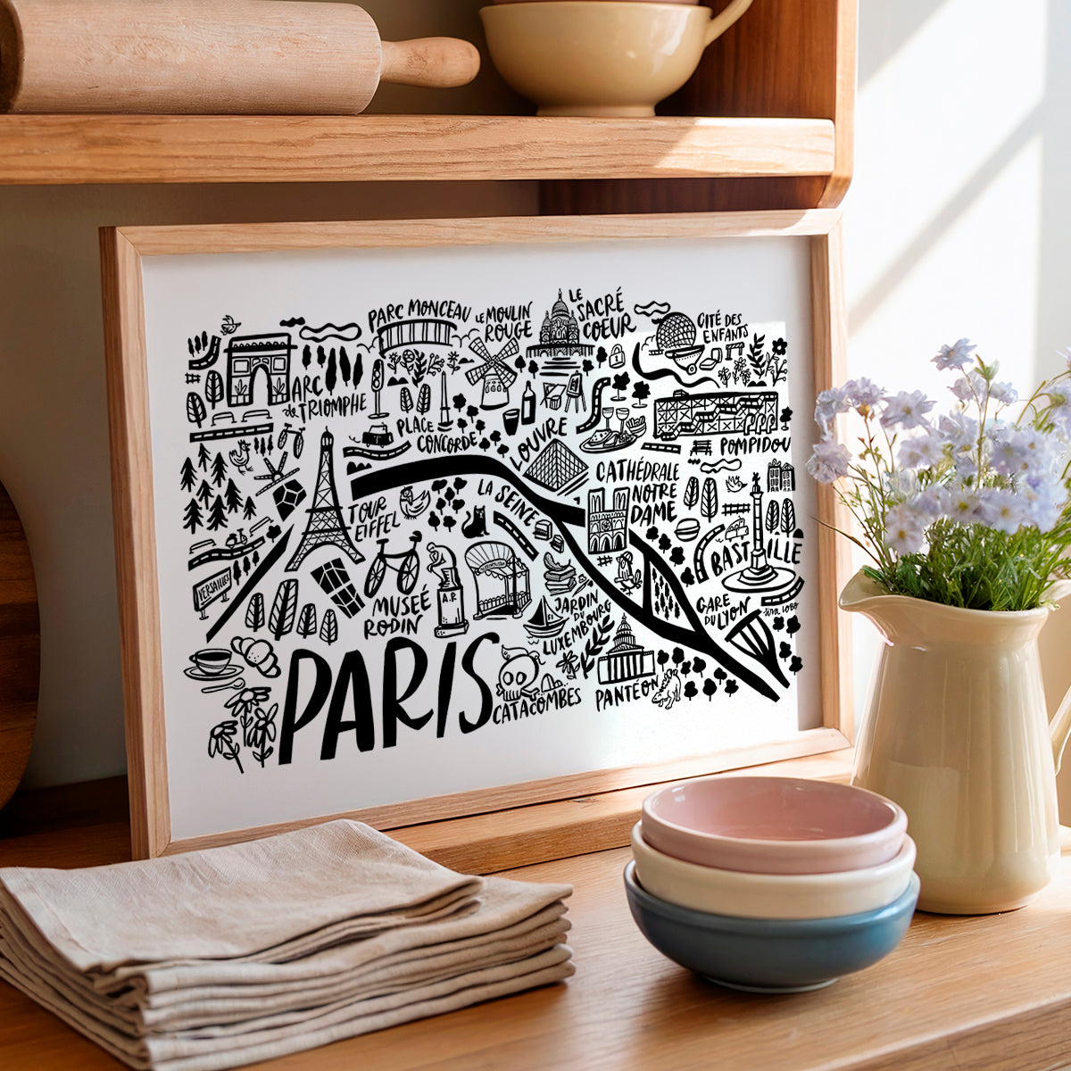 Framed map of Paris on a wooden shelf with kitchen items.