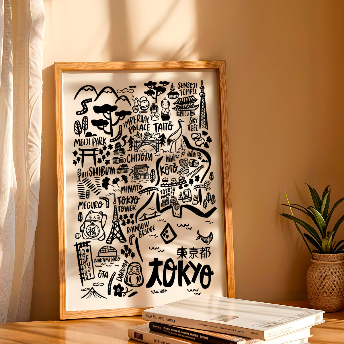 Framed map of Tokyo with black illustrations on a beige wall.