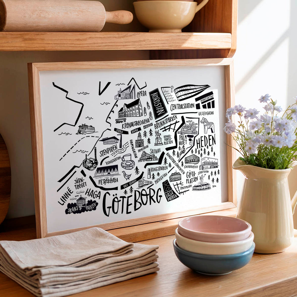 Framed map of Gothenburg on a wooden shelf with kitchen items.