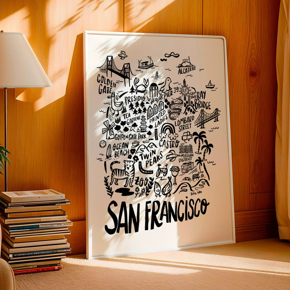 Framed map of San Francisco on a wooden wall with books and a lamp in the background