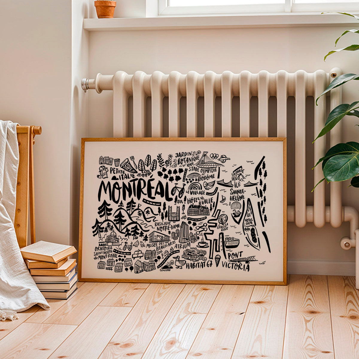Framed map of Montreal on a wooden floor with a radiator and books in the background