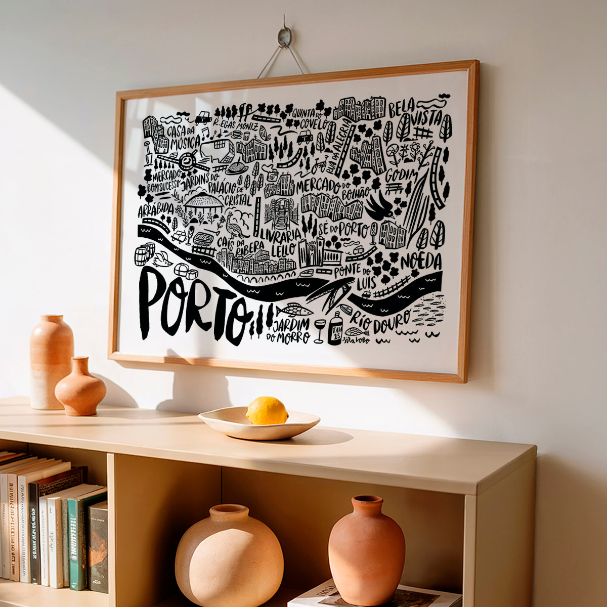 Framed map of Porto on a wall above a shelf with decorative items.