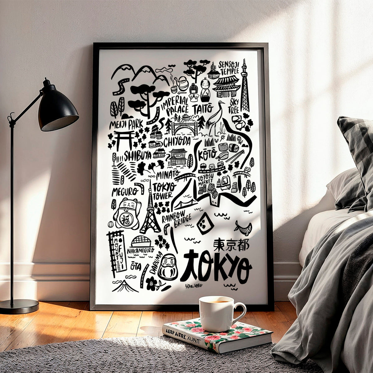 Framed black and white map of Tokyo in a room with a lamp and bed.