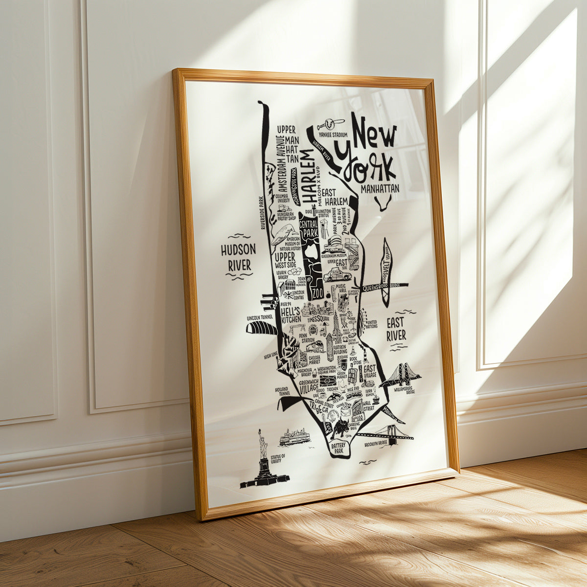Framed map of New York City on a wall with sunlight casting shadows.