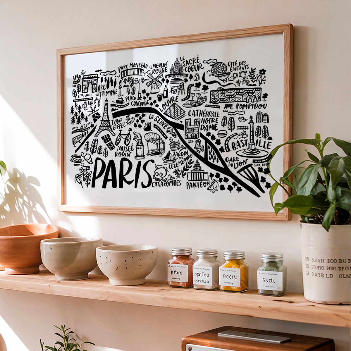 Framed map of Paris on a wall above a shelf with decorative items.