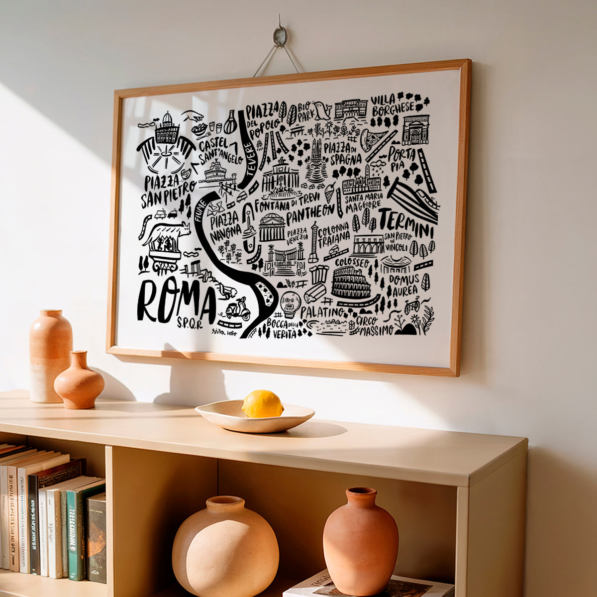 Framed map of Rome on a wall above a shelf with decorative items.