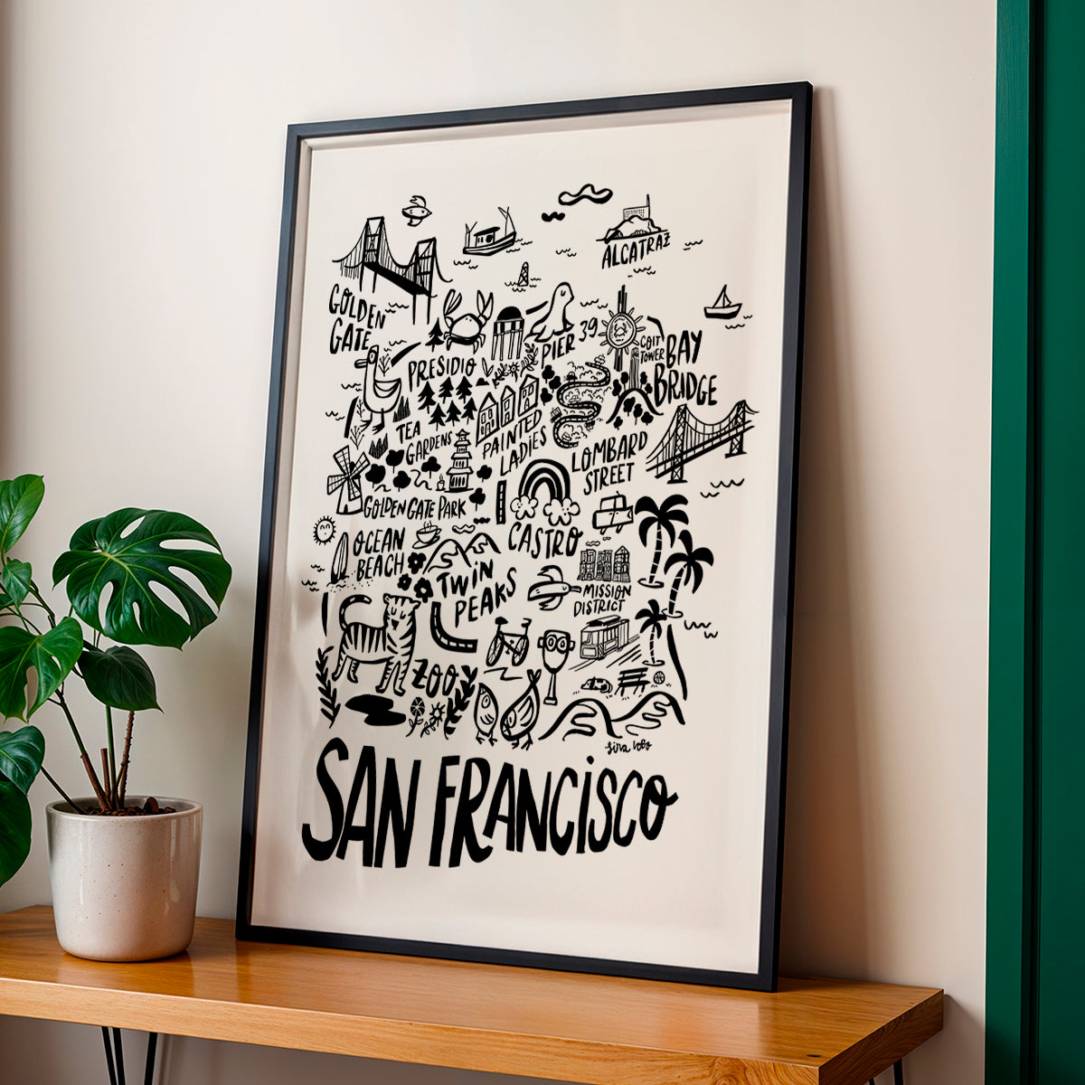Framed artwork of San Francisco with illustrations on a beige wall.