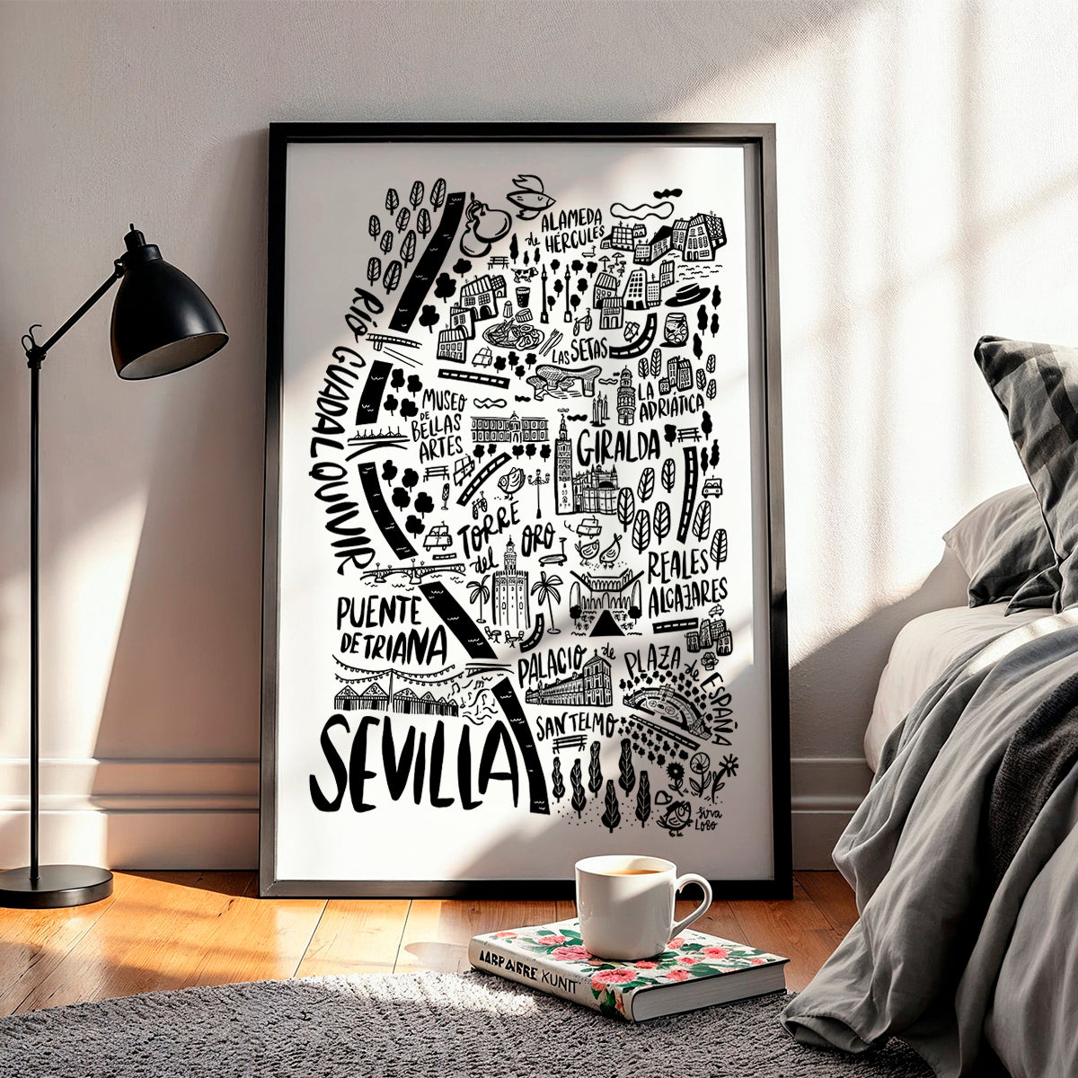 Framed artwork of Sevilla with a cup of coffee on a book in a room setting.