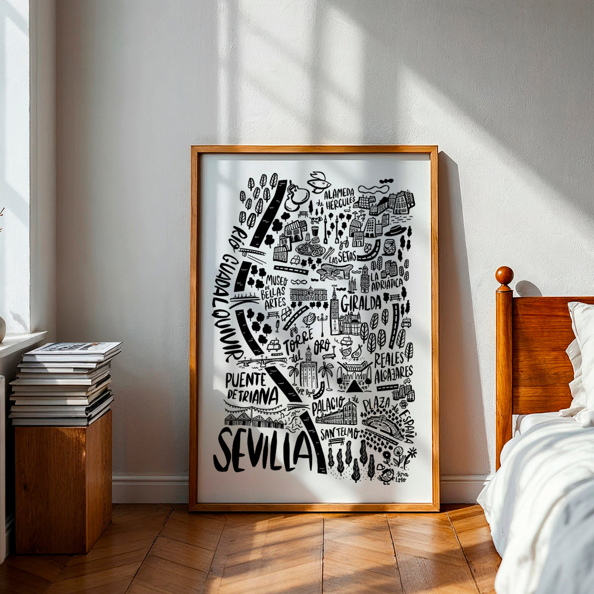 Framed map of Sevilla in a bedroom with wooden bed and books.