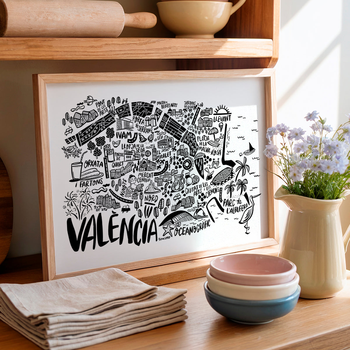 Framed map of Valencia on a wooden shelf with kitchen items.